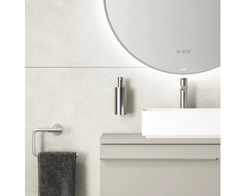Intérieur de salle de bains moderne avec miroir rond, lavabo, robinet, distributeur de savon et porte-serviettes