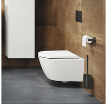 Salle de bains moderne avec WC suspendu, réservoir de chasse, porte-papier toilette et brosse de toilette