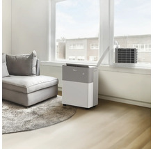 Scène avec un climatiseur mobile dans un salon avec un canapé et une fenêtre