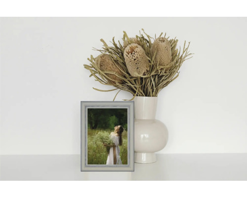 Dekoratives Stillleben mit Bilderrahmen, Vase und Trockenblumenarrangement