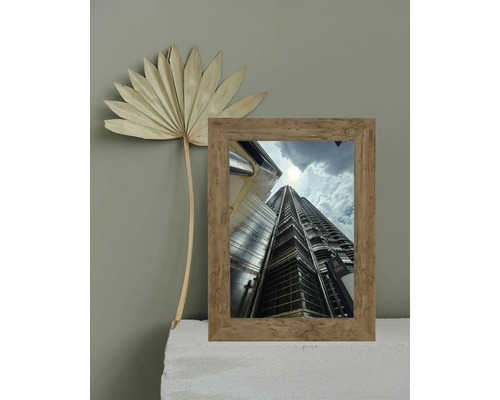 Cadre décoratif avec vue sur un bâtiment et fleur séchée