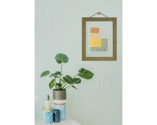 Pièce décorative avec plantes, cadre photo et accessoires pour la maison.