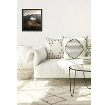 Salon avec canapé, coussins, tapis et paysage encadré