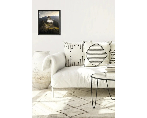 Salon avec canapé, coussins, tapis et paysage encadré