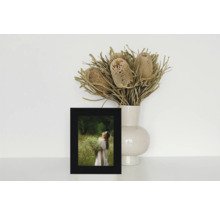 Nature morte décorative avec une photo encadrée et un vase de fleurs séchées