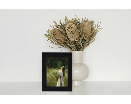 Nature morte décorative avec une photo encadrée et un vase de fleurs séchées