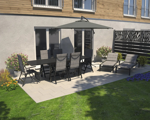 Scène de jardin avec table à manger, chaises, parasol et chaises longues sur une terrasse