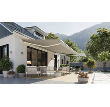 Façade de maison avec store banne déployé et mobilier de jardin sur la terrasse.