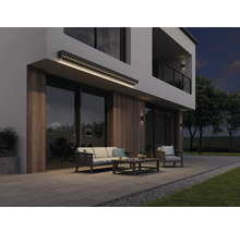 Façade de maison moderne avec store éclairé, mobilier de jardin et terrasse