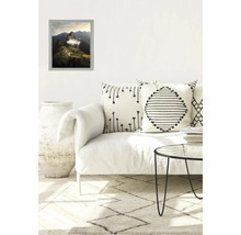 Décoration de salon avec une photo de paysage encadrée, un canapé, des coussins et une table d'appoint