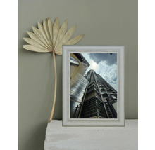 Dekorative Szene mit einem gerahmten Foto eines hohen Gebäudes und einer getrockneten Palme