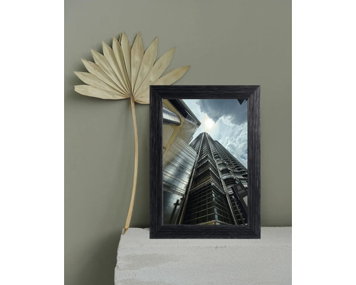 Cadre photo décoratif avec une photo des tours Petronas et une feuille de palmier séchée