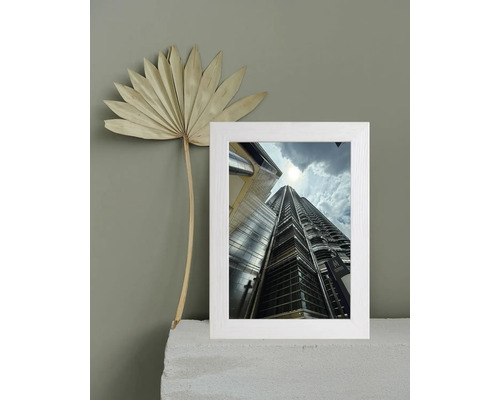 Cadre photo décoratif avec motif architectural et fleur séchée comme décoration de table