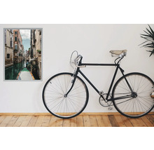 Vélo décoratif à côté d'une peinture murale encadrée représentant un canal vénitien