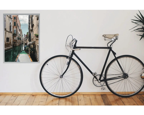 Vélo décoratif à côté d'une peinture murale encadrée représentant un canal vénitien