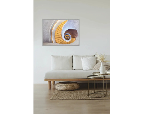 Un salon avec un canapé, un tapis et une photo d'un escalier en colimaçon