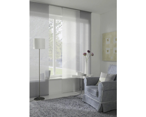 Salon avec rideaux coulissants, fauteuil, lampadaire et tapis