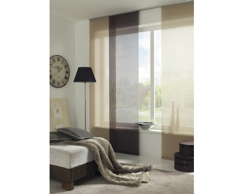 Salon avec rideaux coulissants devant la fenêtre, une horloge au mur et un lit avec des coussins