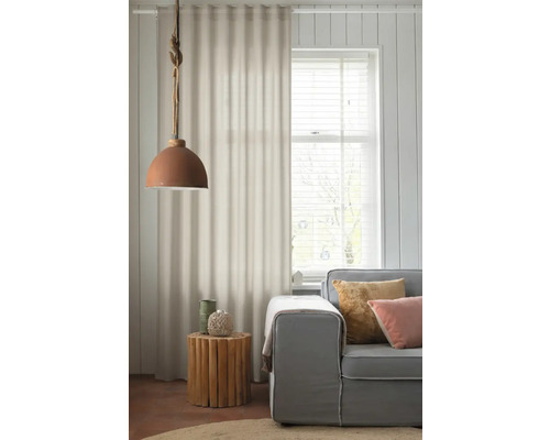 Salon avec canapé gris, table d'appoint en bois, rideaux et suspension