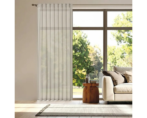 Salon avec rideau clair devant une fenêtre