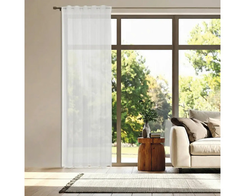 Salon lumineux avec fenêtres, canapé et rideau