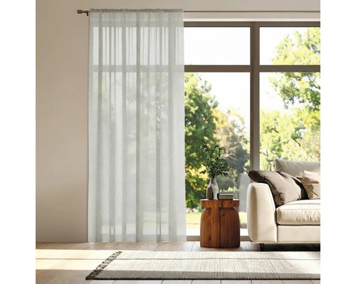 Salon avec rideau devant la fenêtre, canapé et tapis