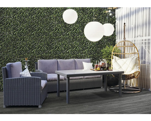 Gartenlounge-Set mit Sofa, Sessel, Tisch und Hängekorb auf einer Terrasse mit Hintergrund einer Pflanzenwand