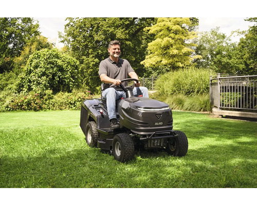 Un homme conduit une tondeuse autoportée AL-KO sur une pelouse.
