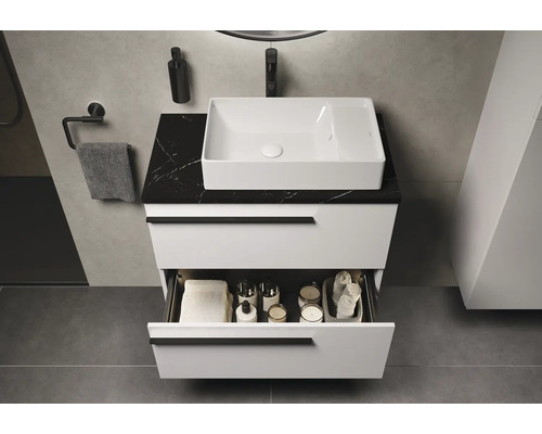 Modernes Badezimmer mit weissem Waschtisch, schwarzer Marmorplatte und offenem Schubladeninhalt