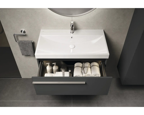 Modernes Badezimmer mit Waschtisch, offenem Schubfach, Handtüchern und Pflegeprodukten