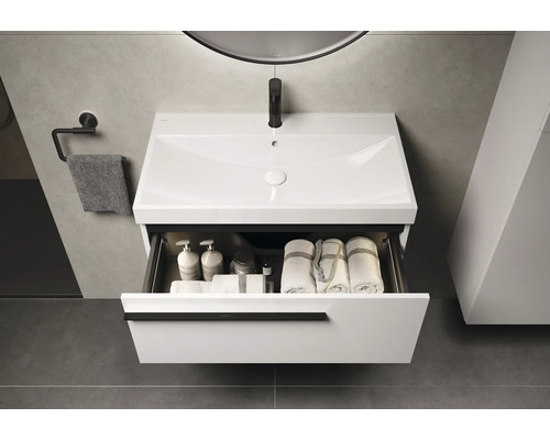 Modernes Badezimmer mit weissem Waschtischunterschrank, offenem Schubfach und Handtüchern