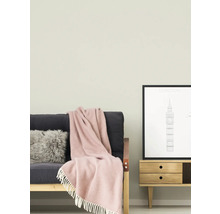 Wohnzimmer mit Sofa, Kissen, Decke, Kommode und gerahmtem Bild