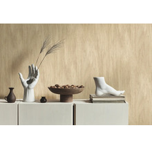 Scène décorative avec un vase en forme de main, un bol avec des billes et une sculpture de pied sur une armoire