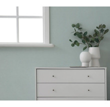 Commode avec décorations devant un mur près d'une fenêtre