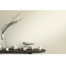 Scène décorative avec vase, branches, coupe et figurines en céramique sur une table