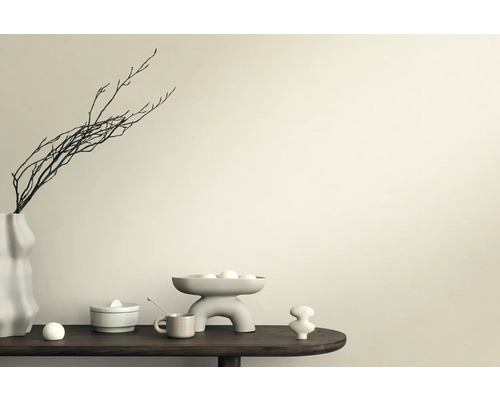 Scène décorative avec vase, branches, coupe et figurines en céramique sur une table