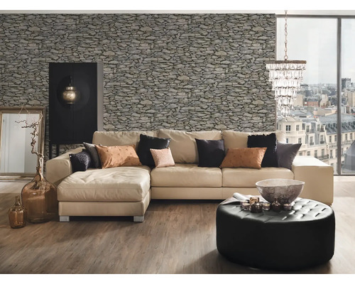 Wohnzimmer mit Sofa, Sessel und Steinwandtapete