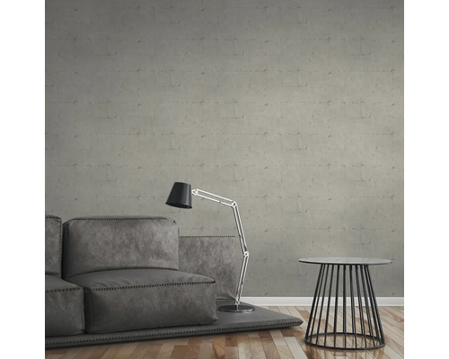 Graue Sofagarnitur mit Stehlampe und Beistelltisch vor einer grauen Wand