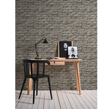 Bureau avec bureau, chaise, lampe de bureau et papier peint à motif de briques pour une atmosphère productive.