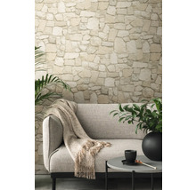 Wohnzimmer mit Steinwandtapete, Sofa und Beistelltisch.