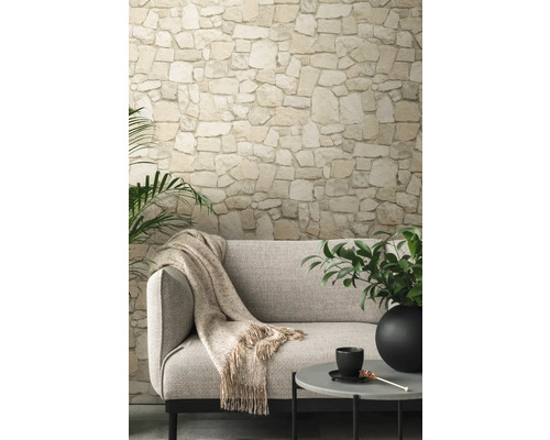 Wohnzimmer mit Steinwandtapete, Sofa und Beistelltisch.