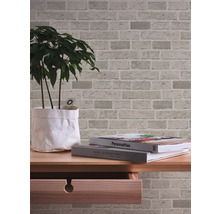 Papier peint à motif de briques sur un mur derrière une table.