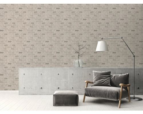 Salon avec papier peint briques, fauteuil, lampadaire et commode