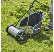 Tondeuse à gazon manuelle sur une pelouse avec bac de ramassage