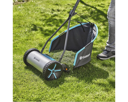Tondeuse à gazon manuelle sur une pelouse avec bac de ramassage
