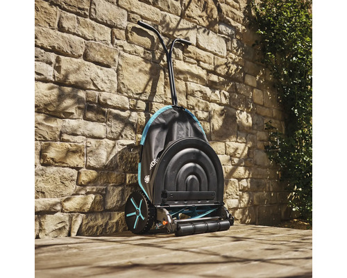 Tondeuse hélicoïdale Gardena devant un mur de pierre