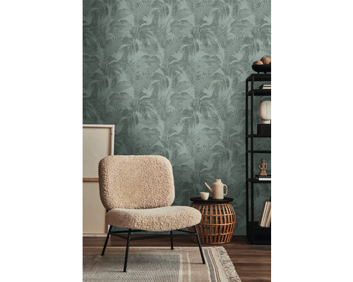 Einrichtungsbeispiel mit einer Deko-Tapete mit Pflanzenmuster, einem Sessel, einem Beistelltisch und einem Regal.