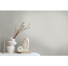 Scène décorative avec bougies, vase, branches, horloge et sculpture sur une table.