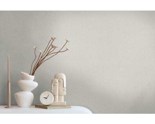 Scène décorative avec bougies, vase, branches, horloge et sculpture sur une table.