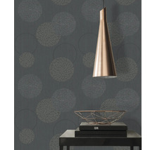 Gros plan d'un mur avec du papier peint à motifs floraux, une lampe et une table